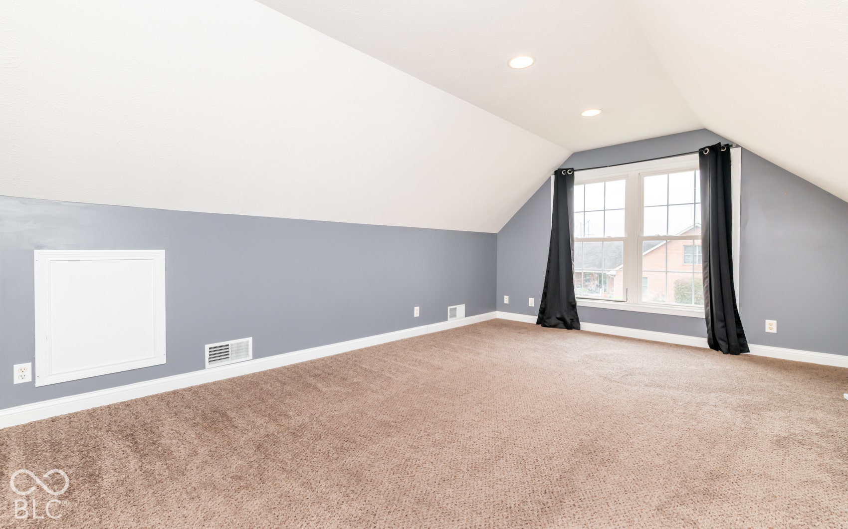 Carpeted flooring, vaulted ceiling, recessed lighting, and a multi-pane window