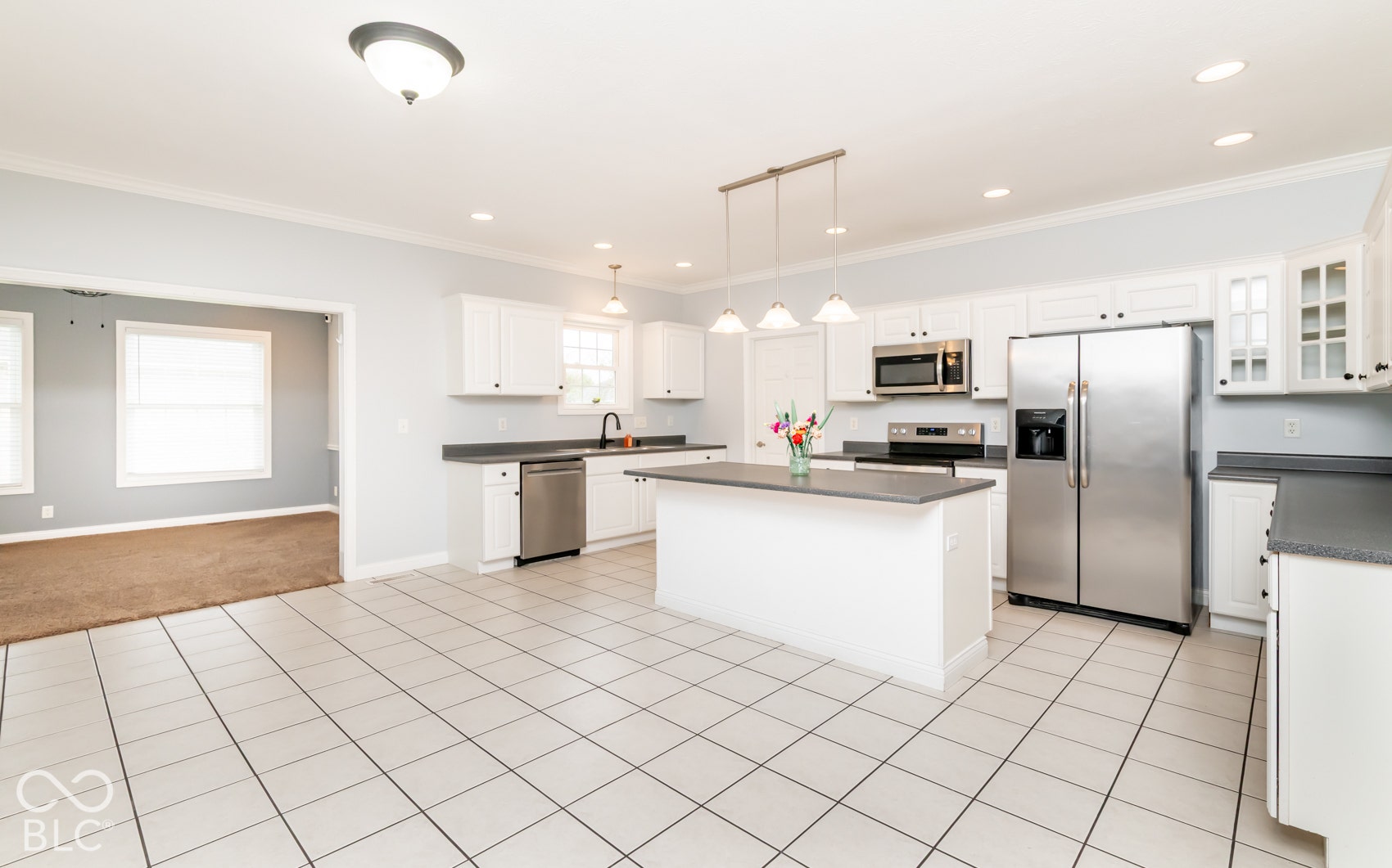 Kitchen featuring white cabinetry, stainless steel appliances, a center island with countertop, tile flooring, and recessed lighting