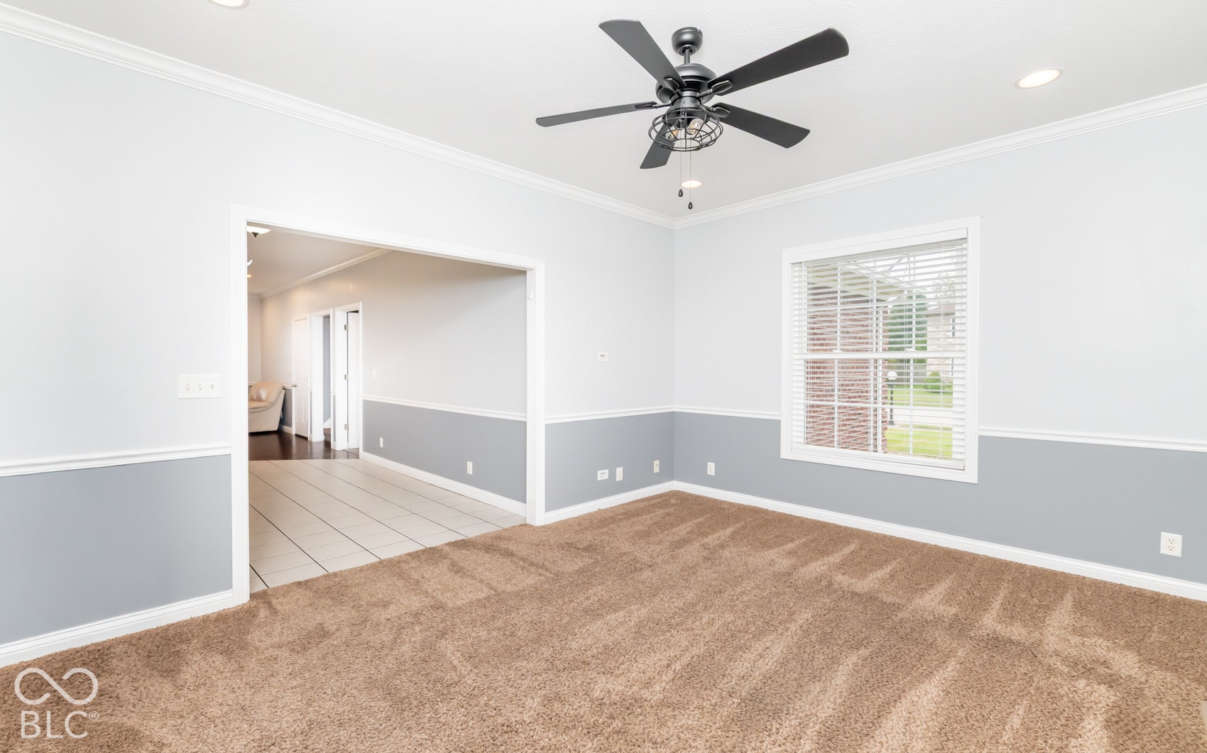Recessed lighting, crown molding, two-tone painted walls, and a ceiling fan with integrated lighting