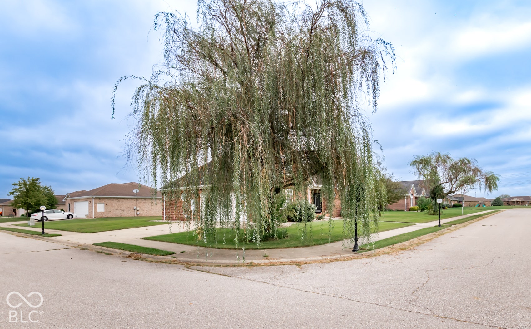 Corner lot with brick exterior and an attached two-car garage