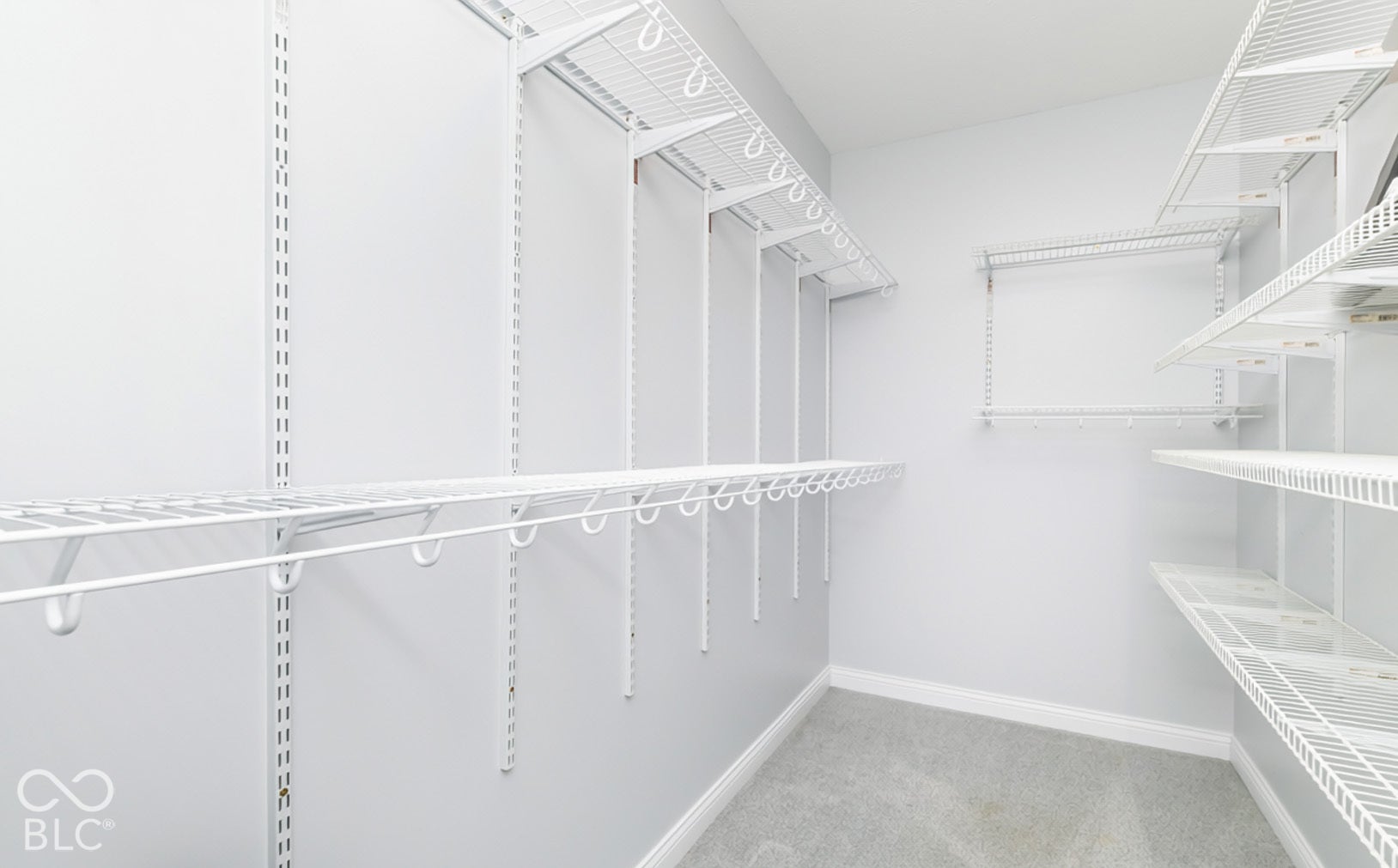 White wire shelving system, multiple shelving tiers, adjustable shelving, and light gray wall paint