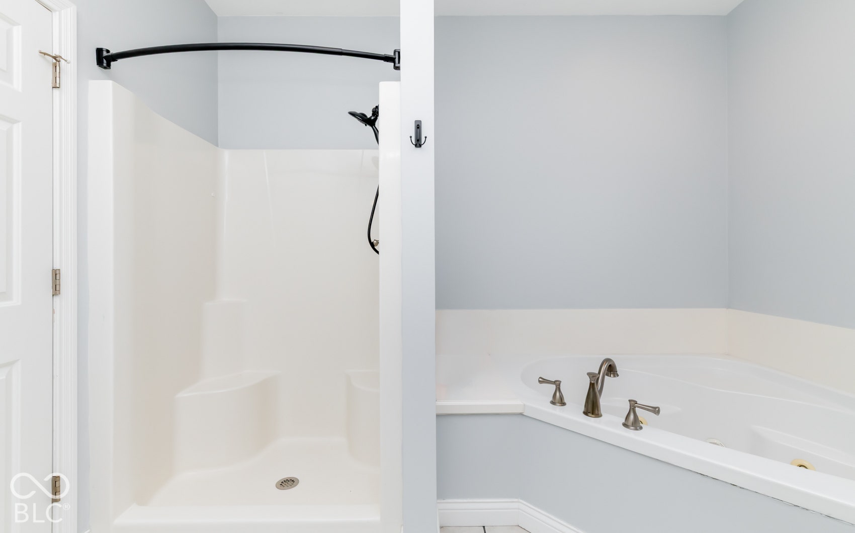 Enclosed shower stall with a built-in bench, integrated corner bathtub, and brushed nickel fixtures