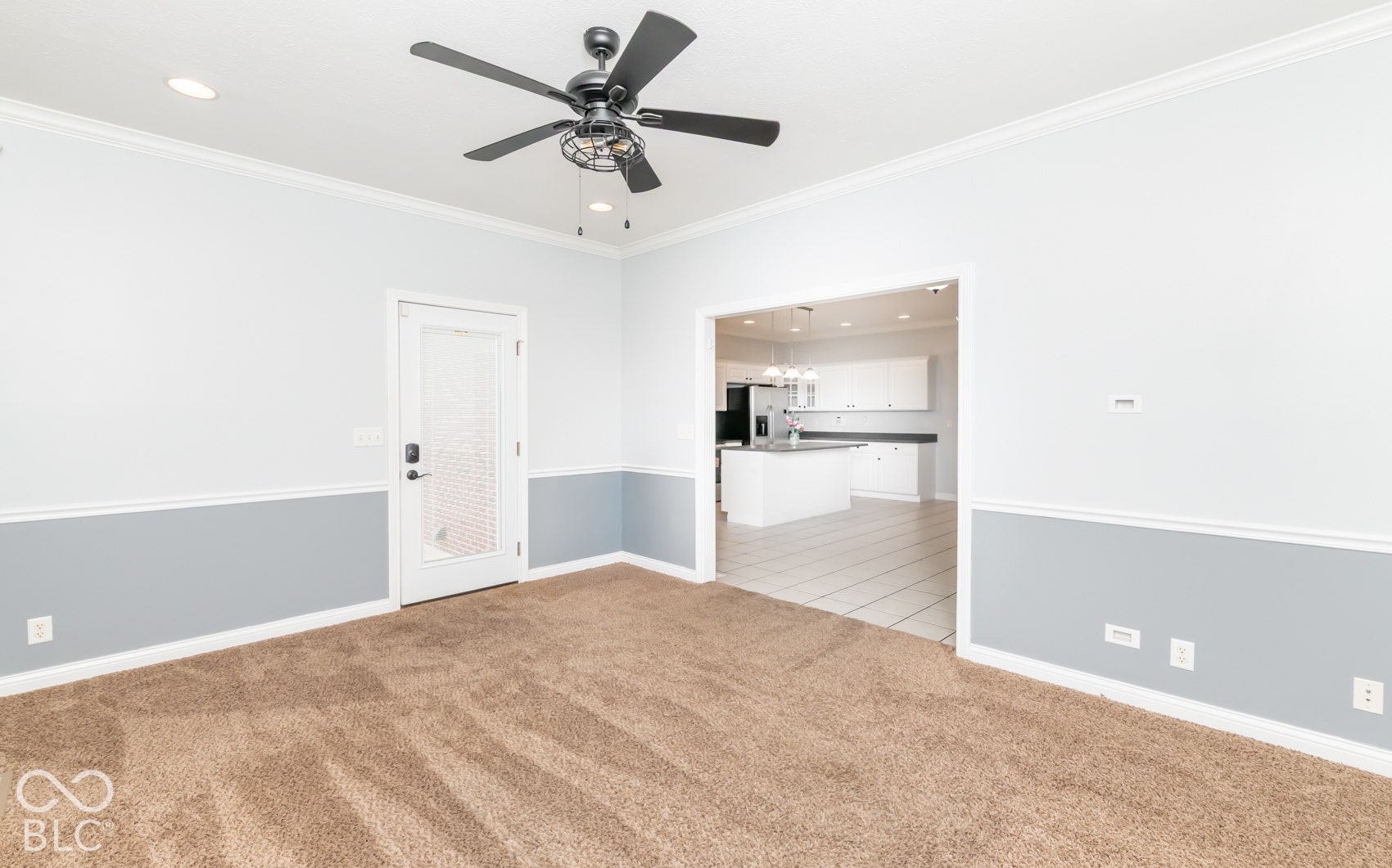 Carpeted interior with light grey and white wall paneling, crown molding, and recessed lighting