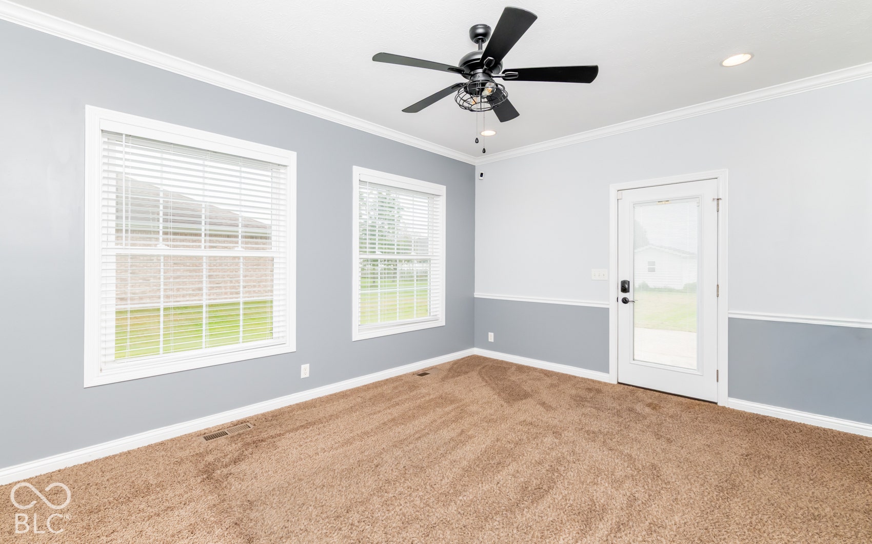 Carpeted room with two windows and a glass-paneled exterior door