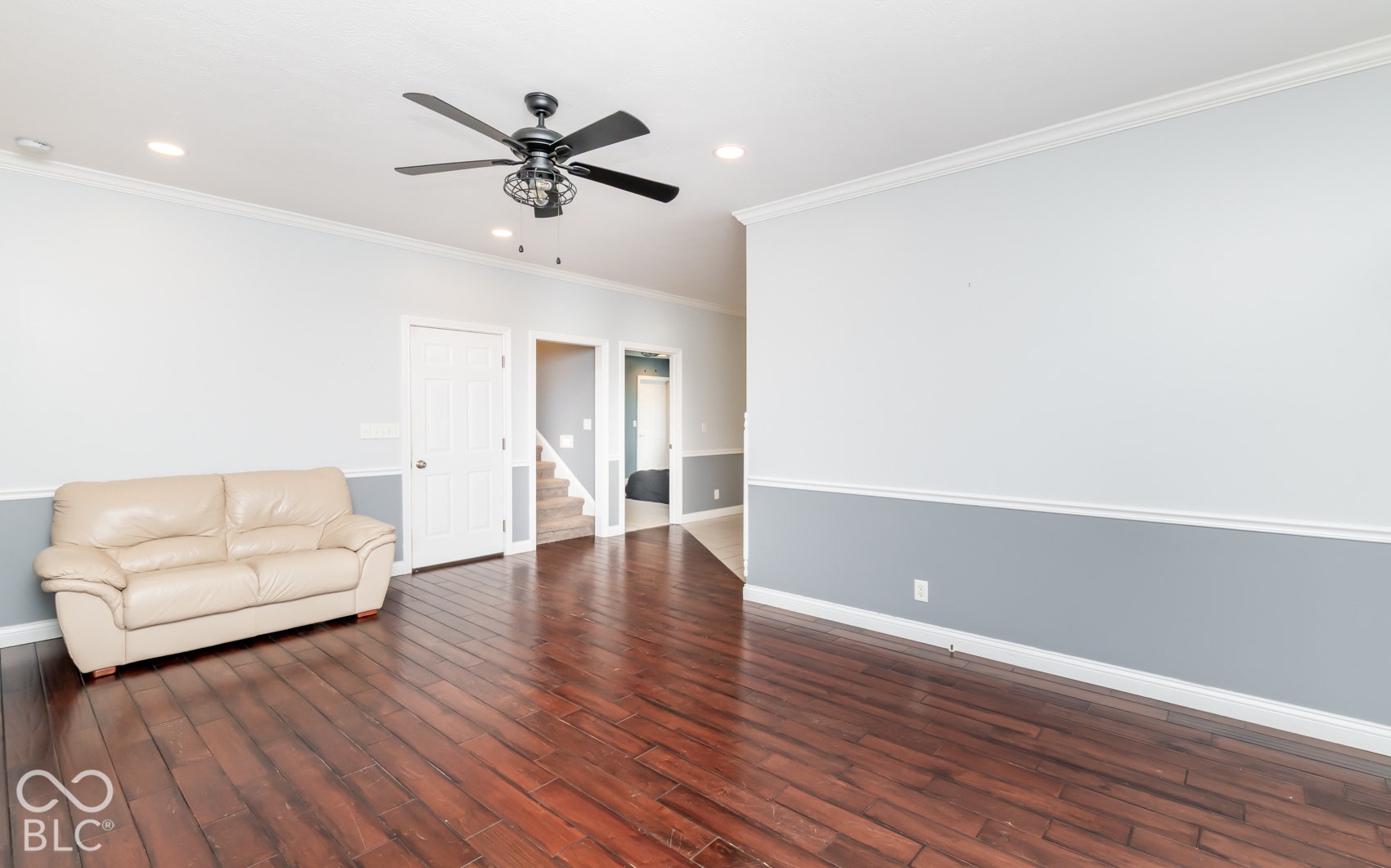 Rich wood-finish flooring, recessed lighting, and a ceiling fan with integrated lighting
