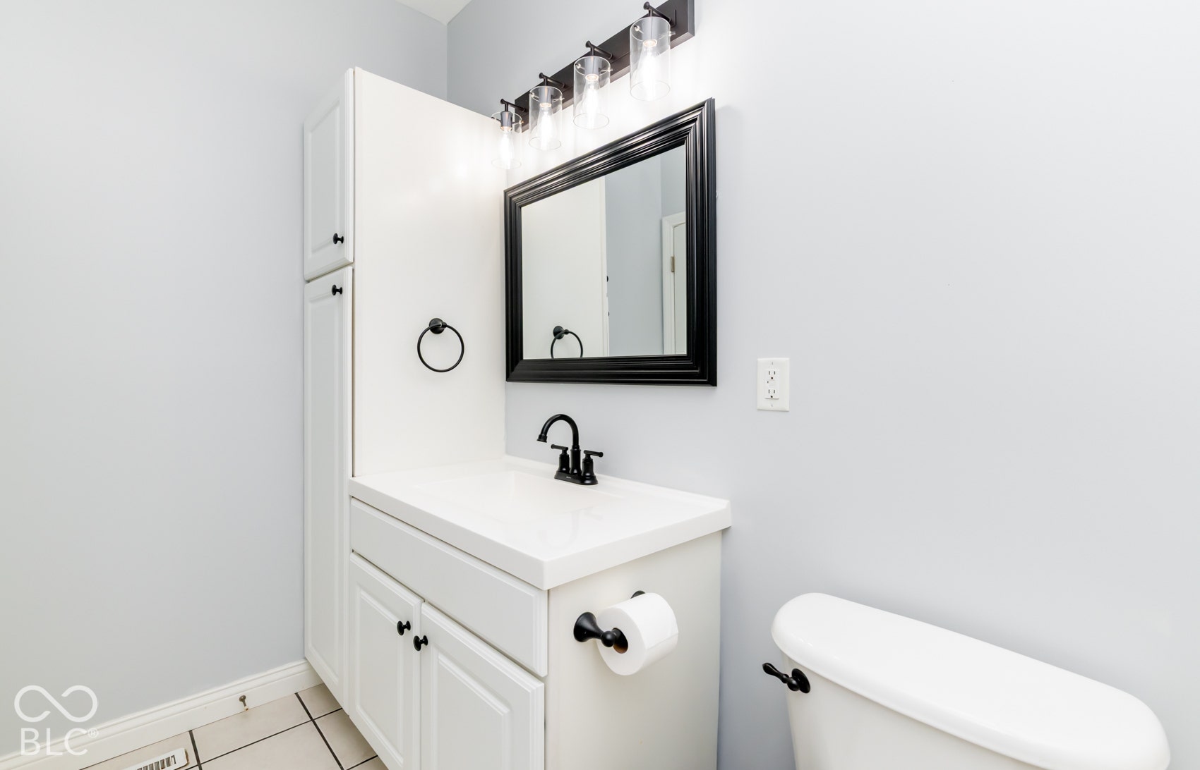 White vanity with a solid surface countertop and undermount sink