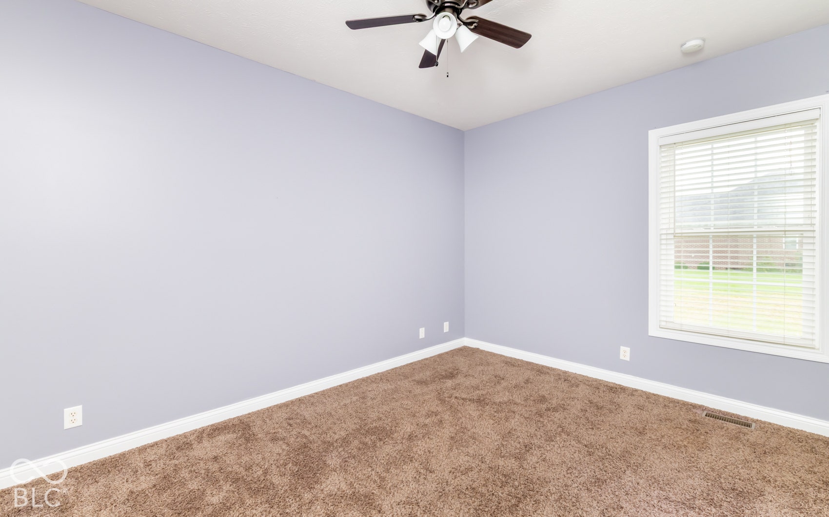 Brown carpeting, light blue wall paint, white trim, window with blinds, and ceiling fan