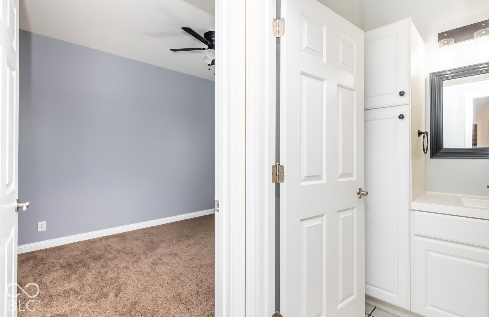 Carpeted bedroom with a ceiling fan