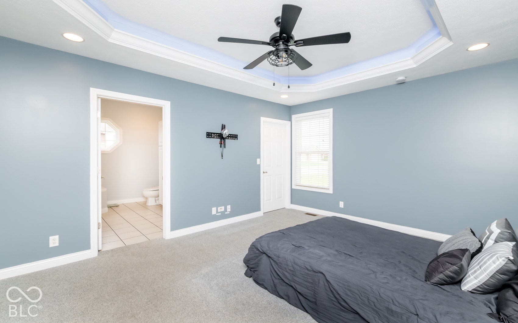 Tray ceiling with crown molding, recessed lighting, ceiling fan, carpeted flooring, and a window with blinds