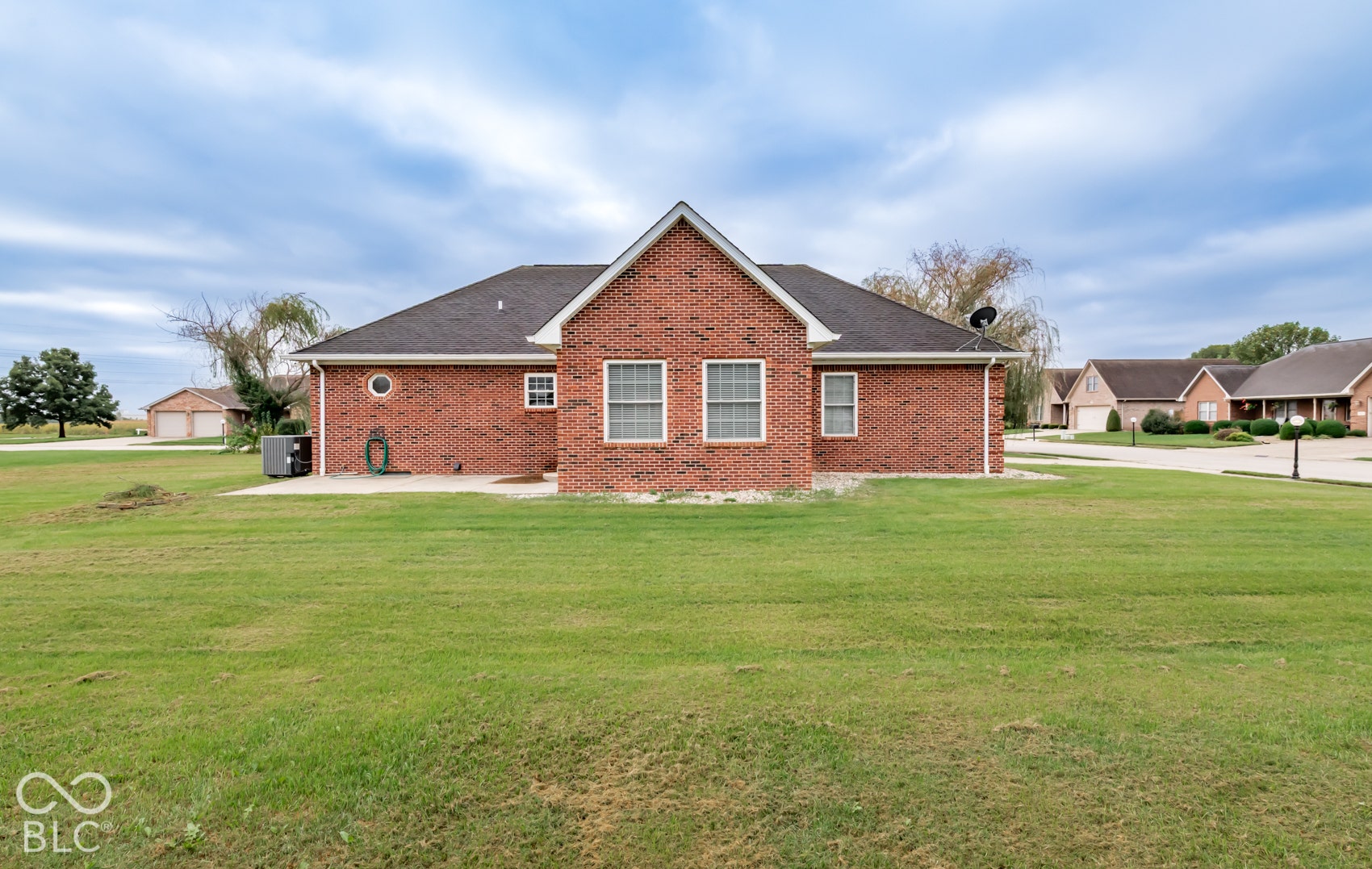 Brick exterior with white window trim and a dark shingle roof