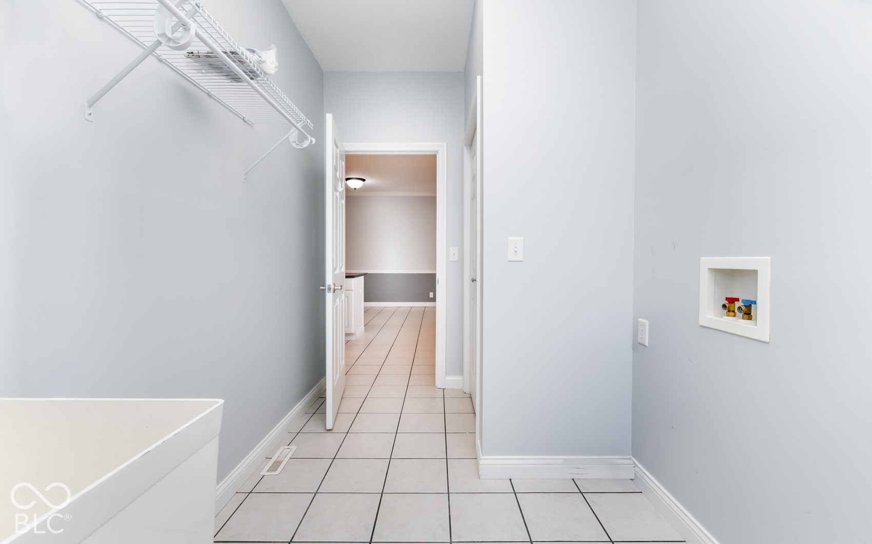 Ceramic tile flooring, built-in wire shelving, and laundry hookups