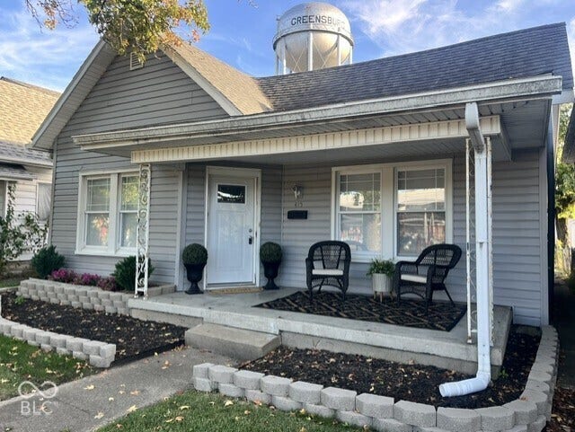 415 W Main, Greensburg, IN 47240 Gray siding exterior with white trim, covered front porch, concrete porch and steps, and decorative porch columns
