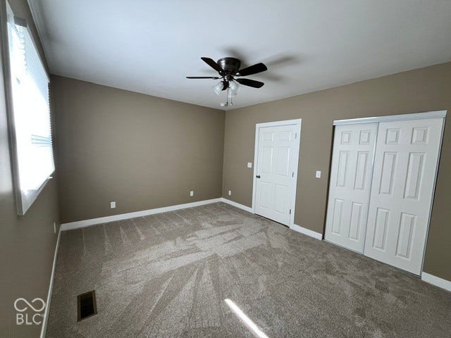 415 W Main, Greensburg, IN 47240 Carpeted room featuring a ceiling fan with lighting, window with blinds, and white paneled doors