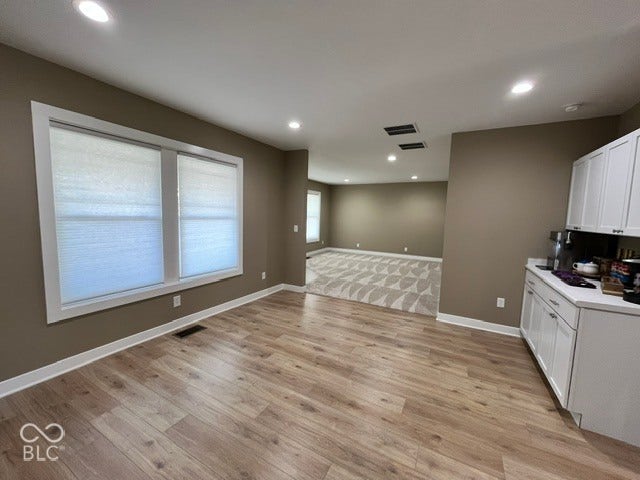 415 W Main, Greensburg, IN 47240 Recessed lighting, laminate wood-finish flooring, white cabinetry, and white window trim and pull down blinds