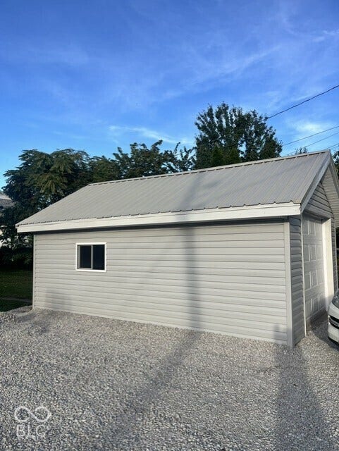 415 W Main, Greensburg, IN 47240 Detached garage featuring light gray siding, a single window, a metal roof, and a gravel driveway