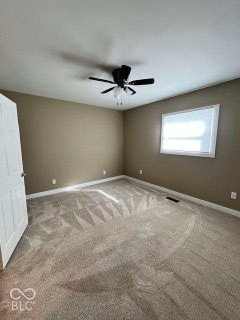 415 W Main, Greensburg, IN 47240 Neutral-toned carpeting, ceiling fan with lighting, window with horizontal blinds, and white trim accents