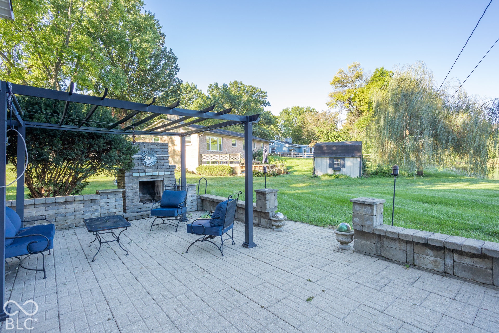 Serene pond views from the lower level living space, with fireplace and pergola
