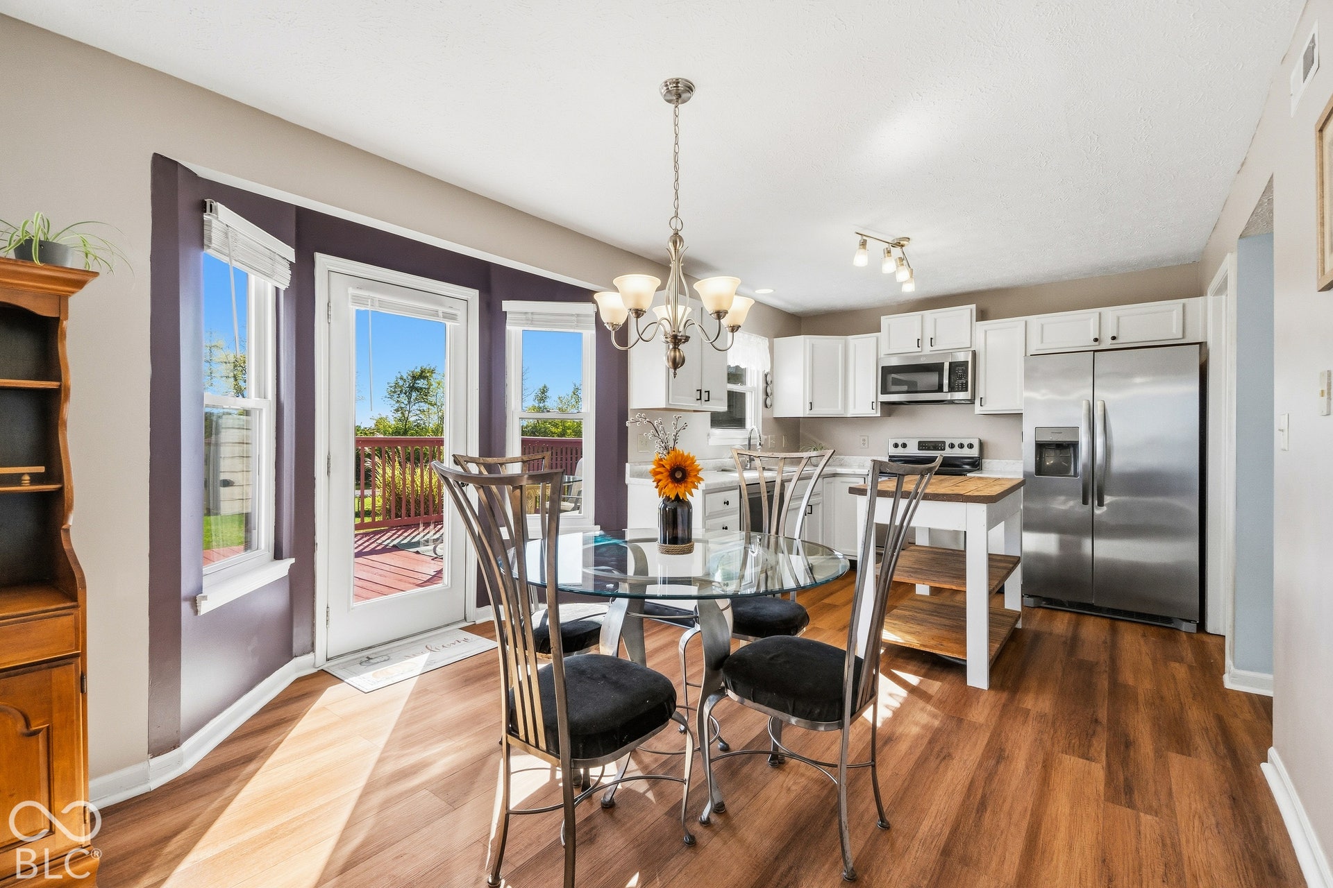 Wood-finish flooring throughout, white cabinetry, and stainless steel appliances