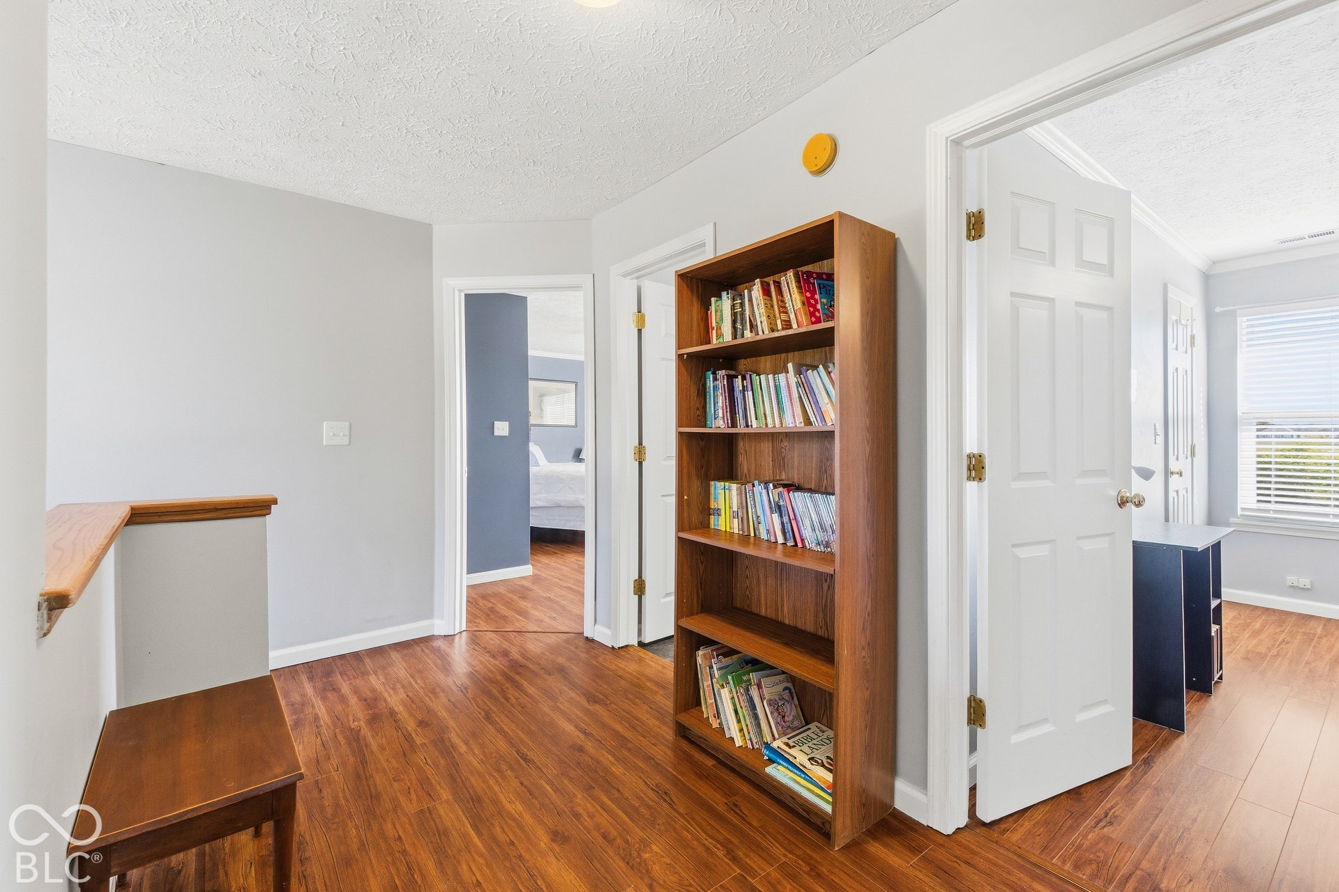 Wood-finish flooring throughout, light gray wall paint, white trim, and white doors
