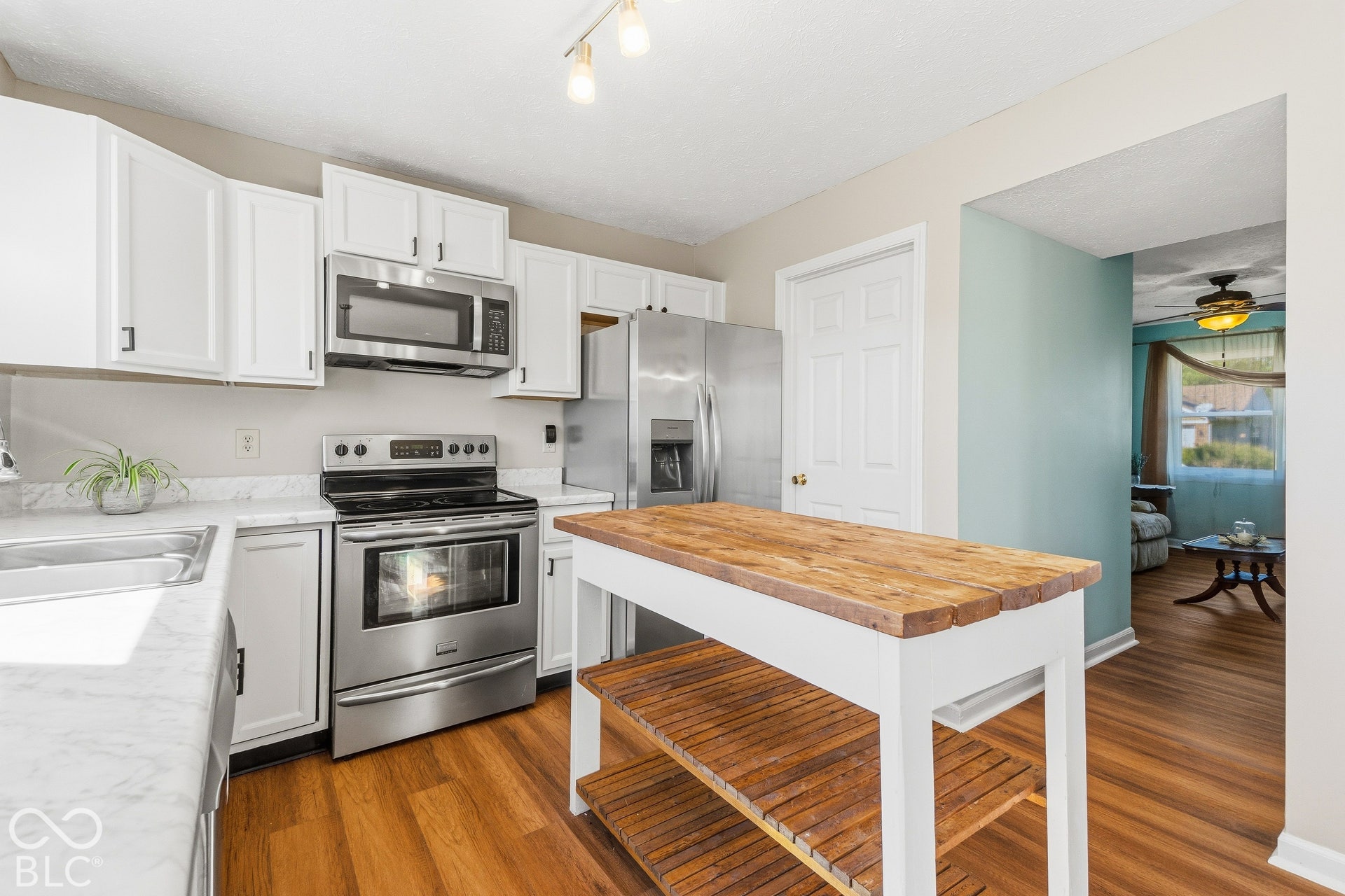 White cabinetry and stainless steel appliances, featuring a freestanding oven with a microwave above