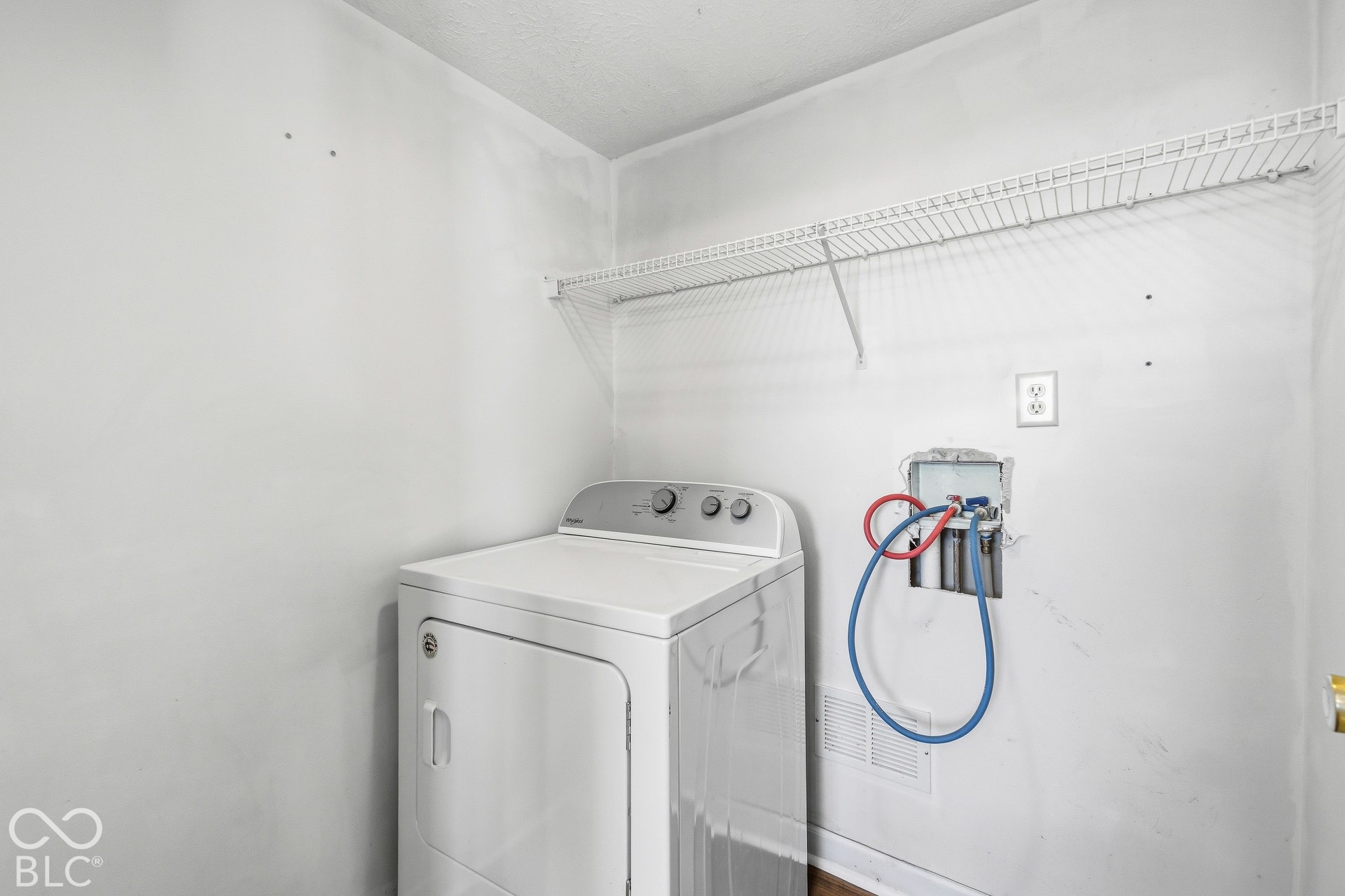 Dedicated laundry area with a wire storage shelf