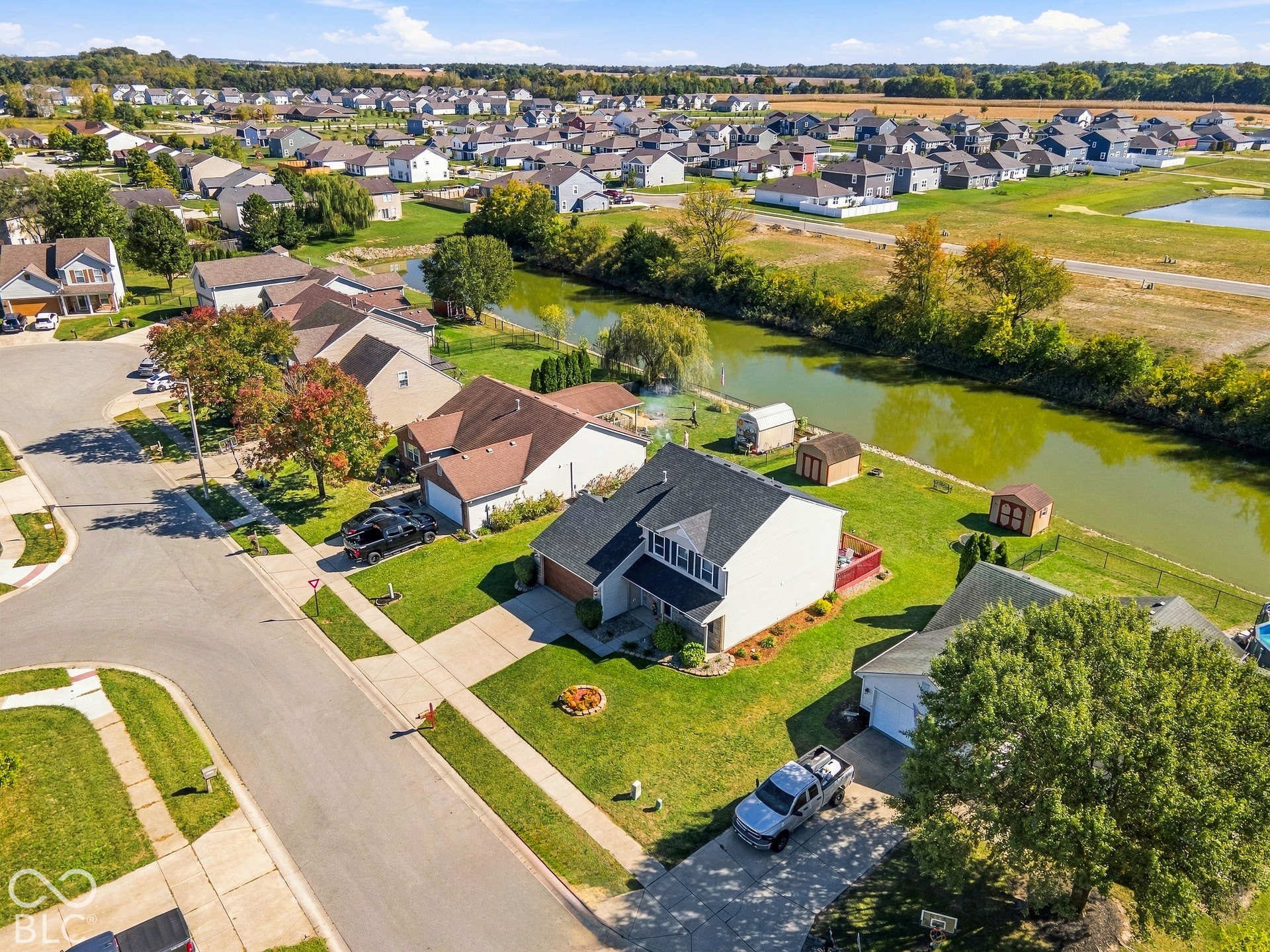 Residential property featuring a two-story structure with a gabled roof, an attached garage, and a fenced backyard
