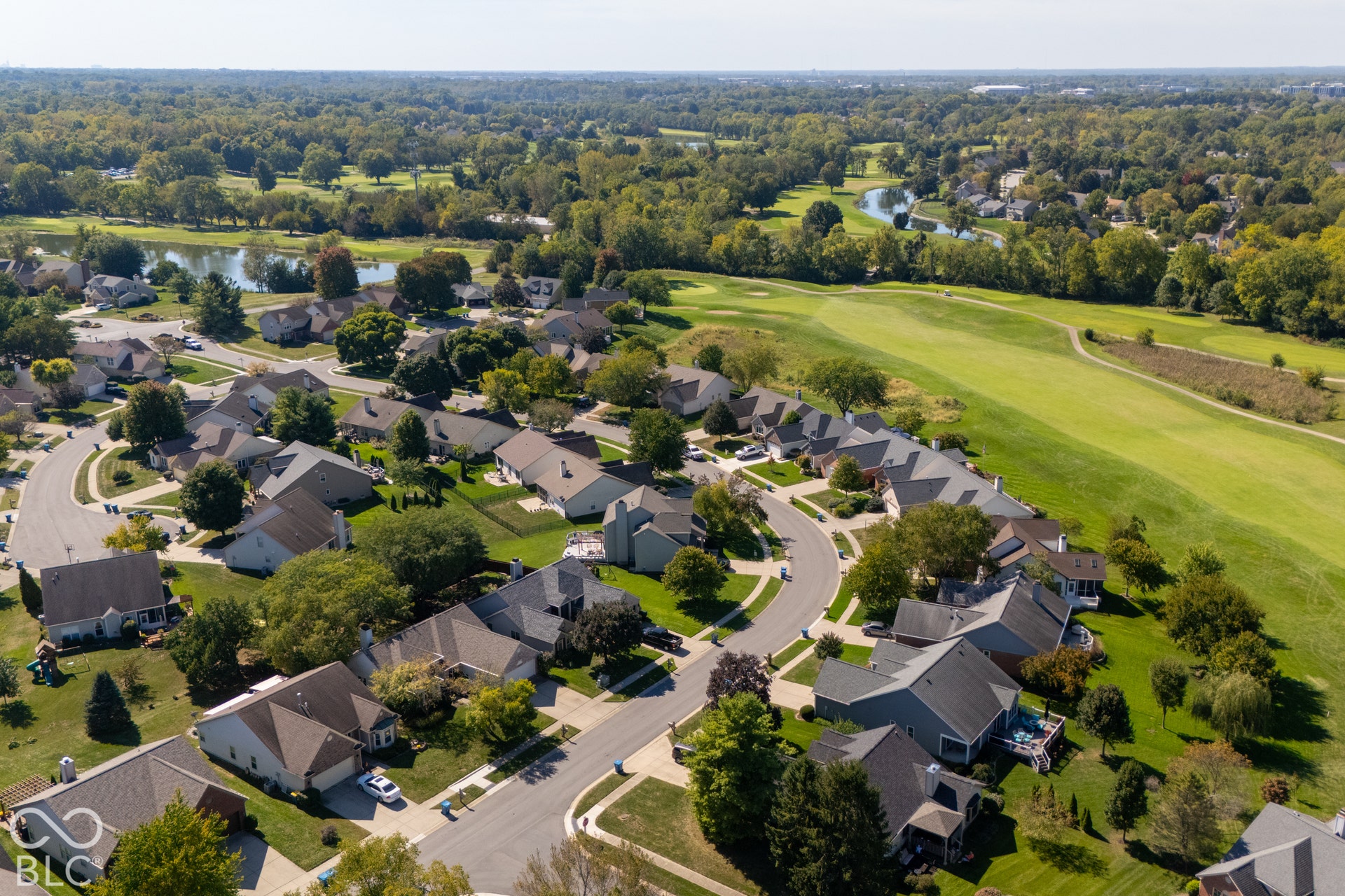Residential properties with landscaped grounds, mature trees, and paved streets