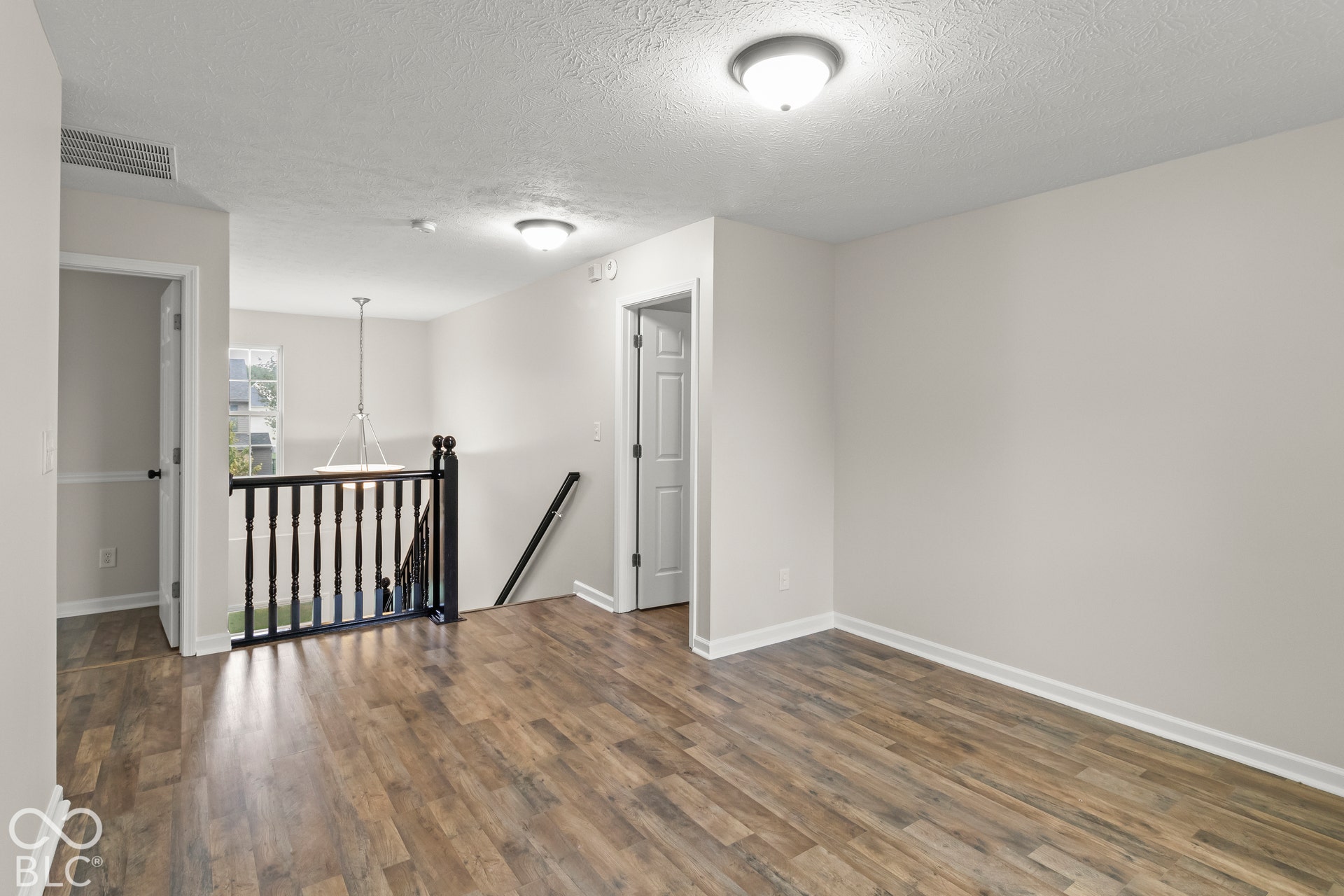 Wood-finish flooring throughout, white baseboards, and light gray walls