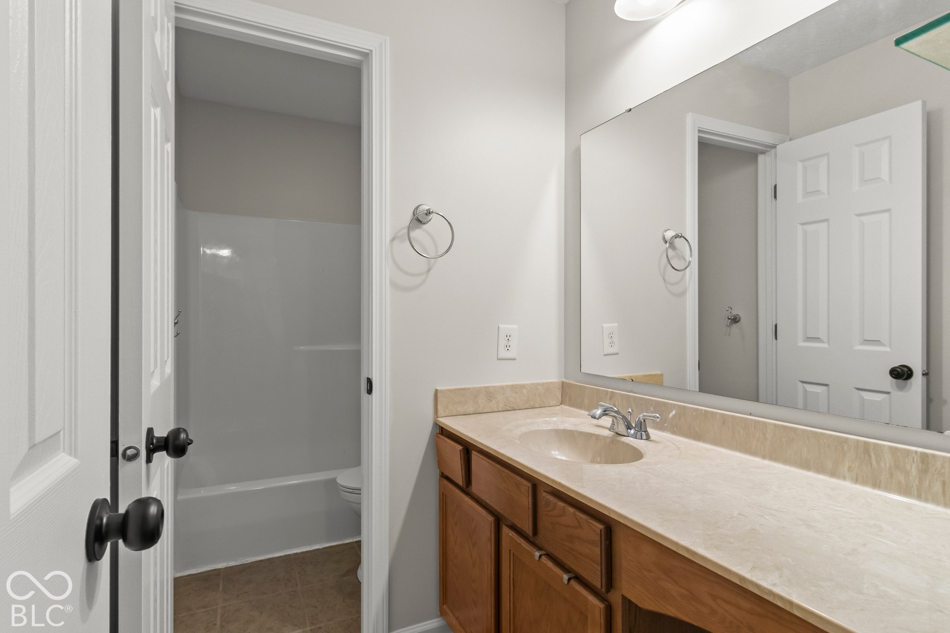 Wood-finish vanity with a built-in sink and an expansive countertop