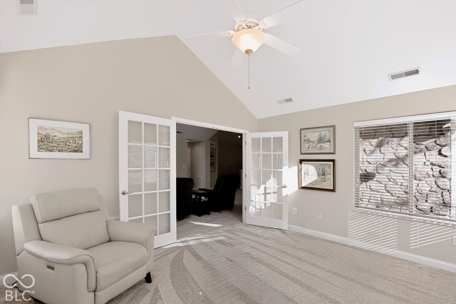 Vaulted ceiling with a ceiling fan, light gray wall paint, and white French doors
