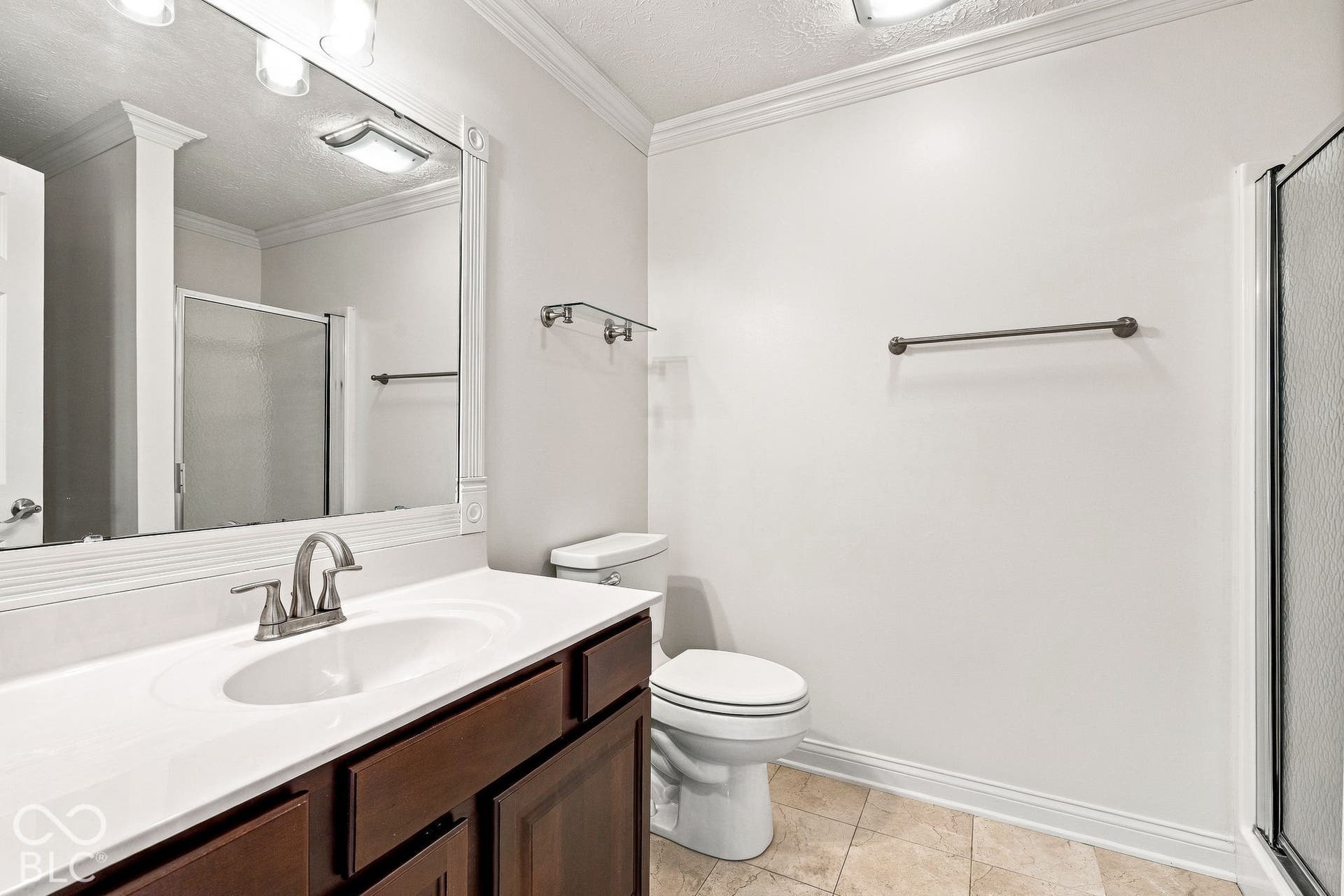 White vanity with a single basin sink, brushed nickel faucet, and integrated white countertop