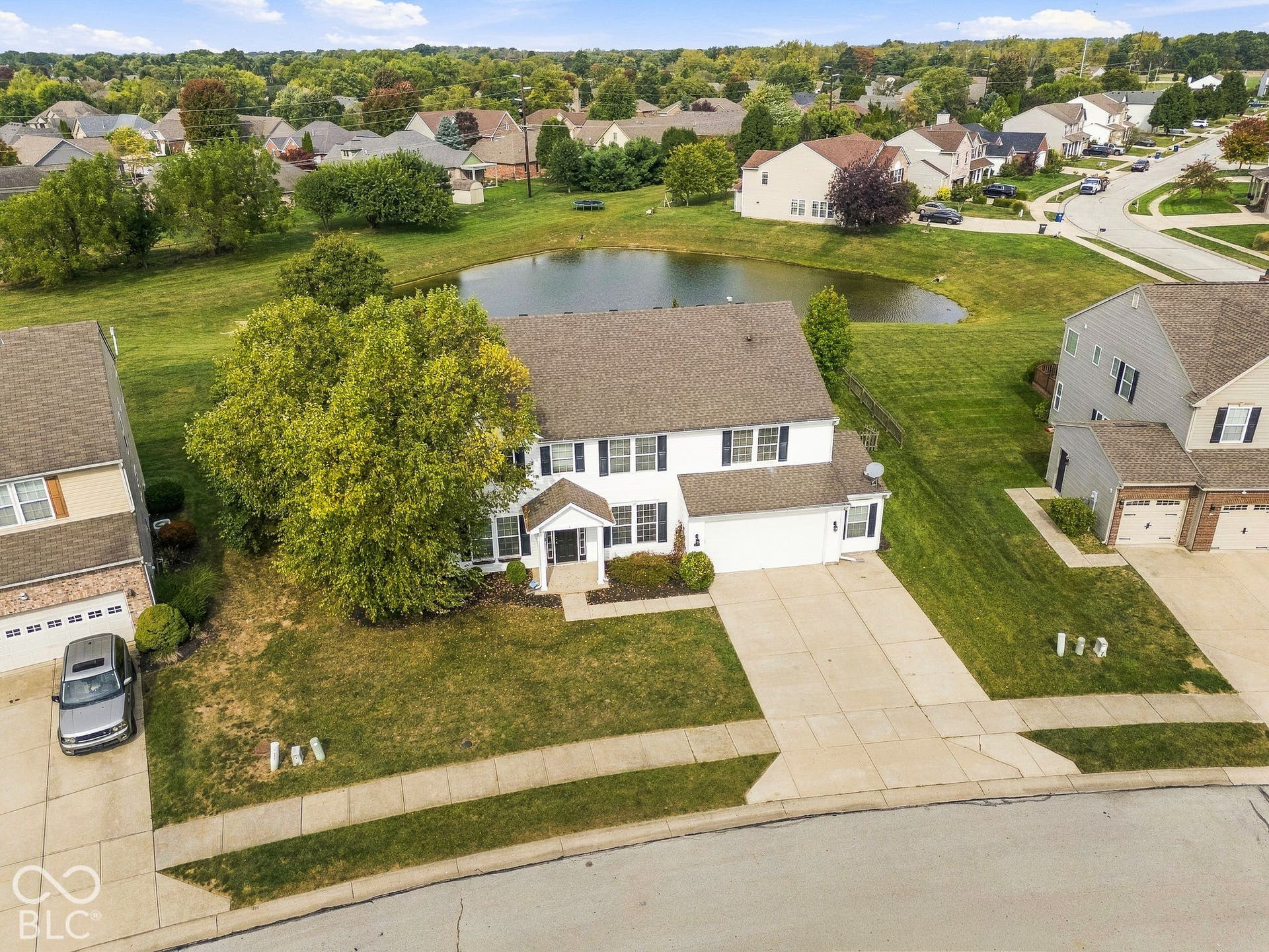 Two-story residence featuring a white exterior with dark shutters, an attached two-car garage, and a concrete driveway