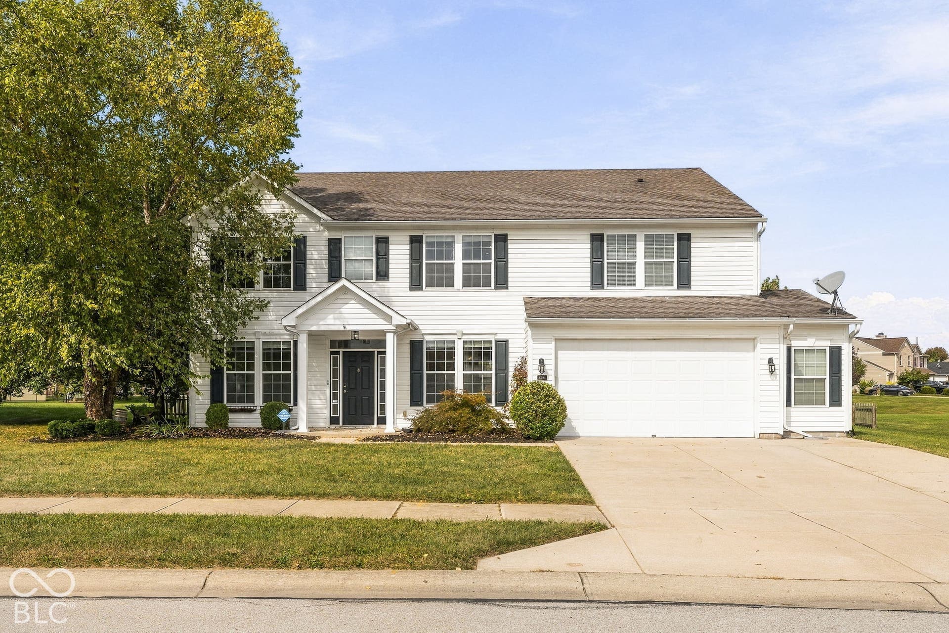 Colonial-style two-story residence featuring a front-gable design with white exterior siding, black shutters, and a covered entry portico