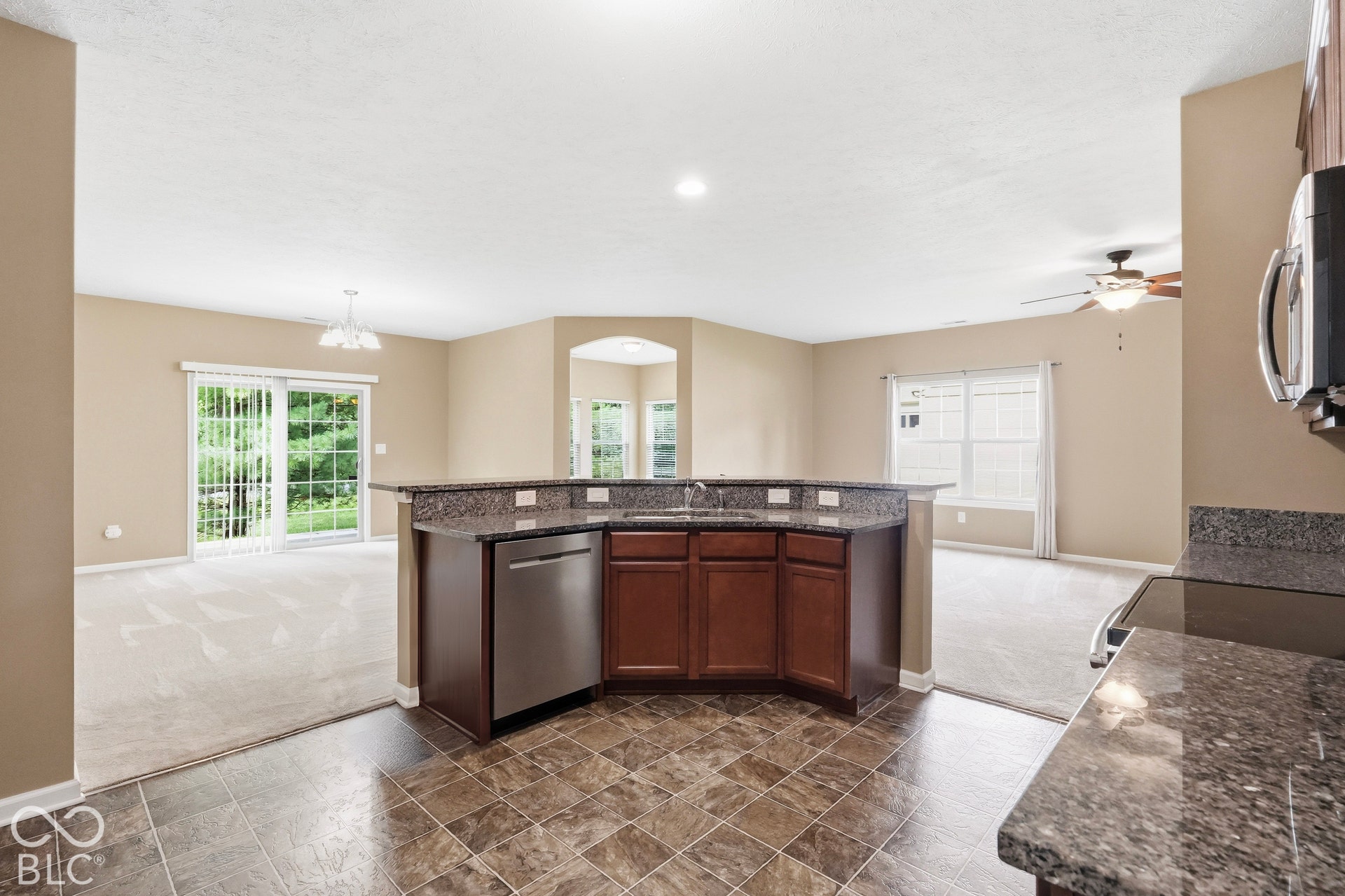 Kitchen island with an undermount sink, integrated dishwasher, and granite countertops