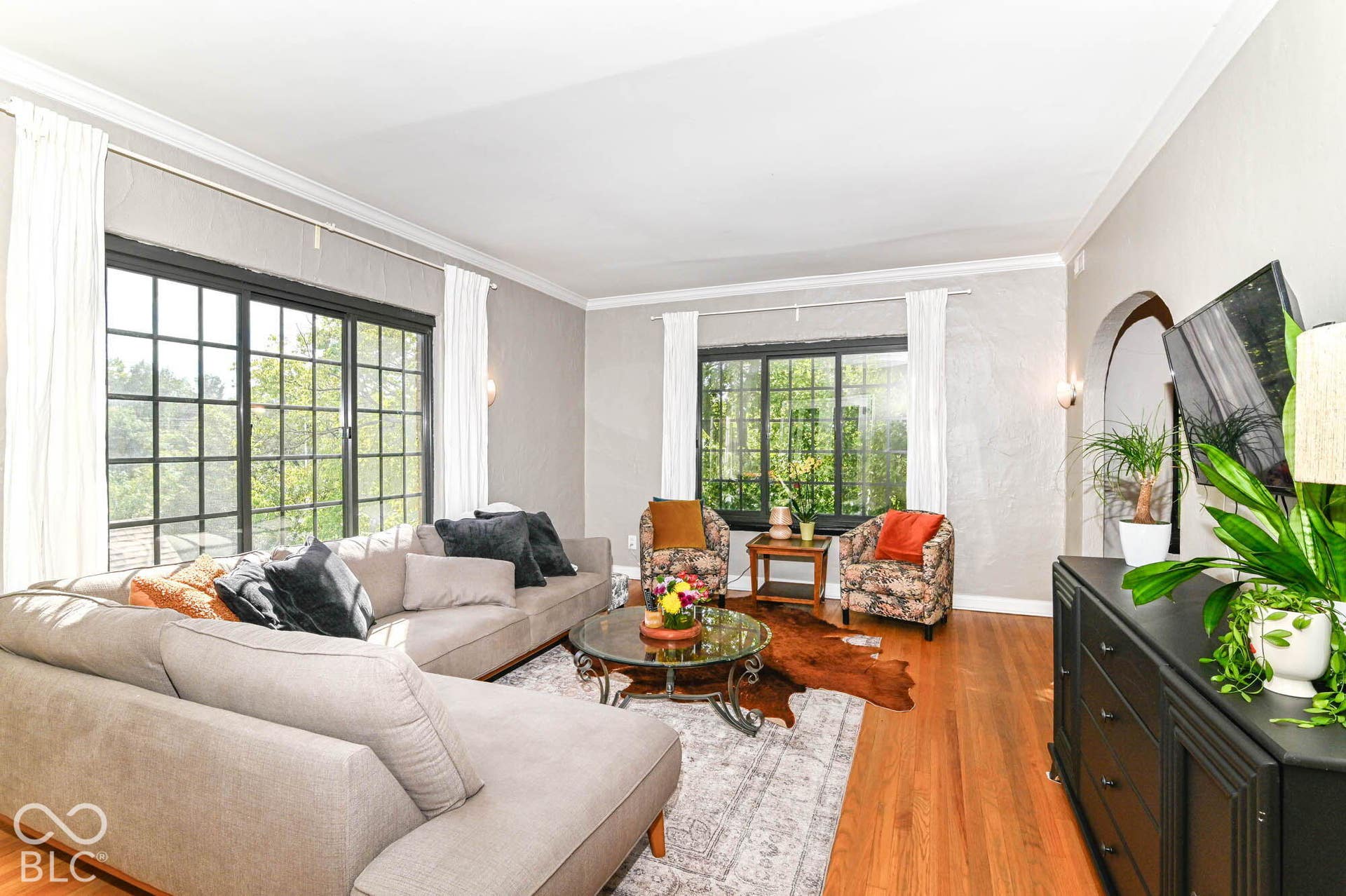 Hardwood flooring, crown molding, and grid-pattern windows