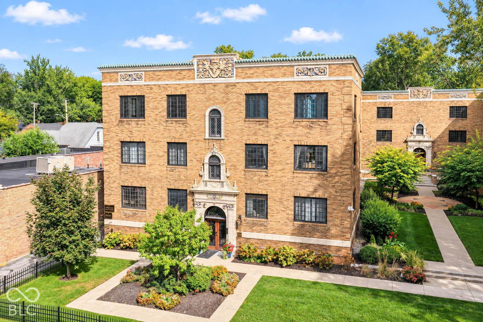Brick exterior building featuring decorative stone accents, arched entryways, and multiple windows