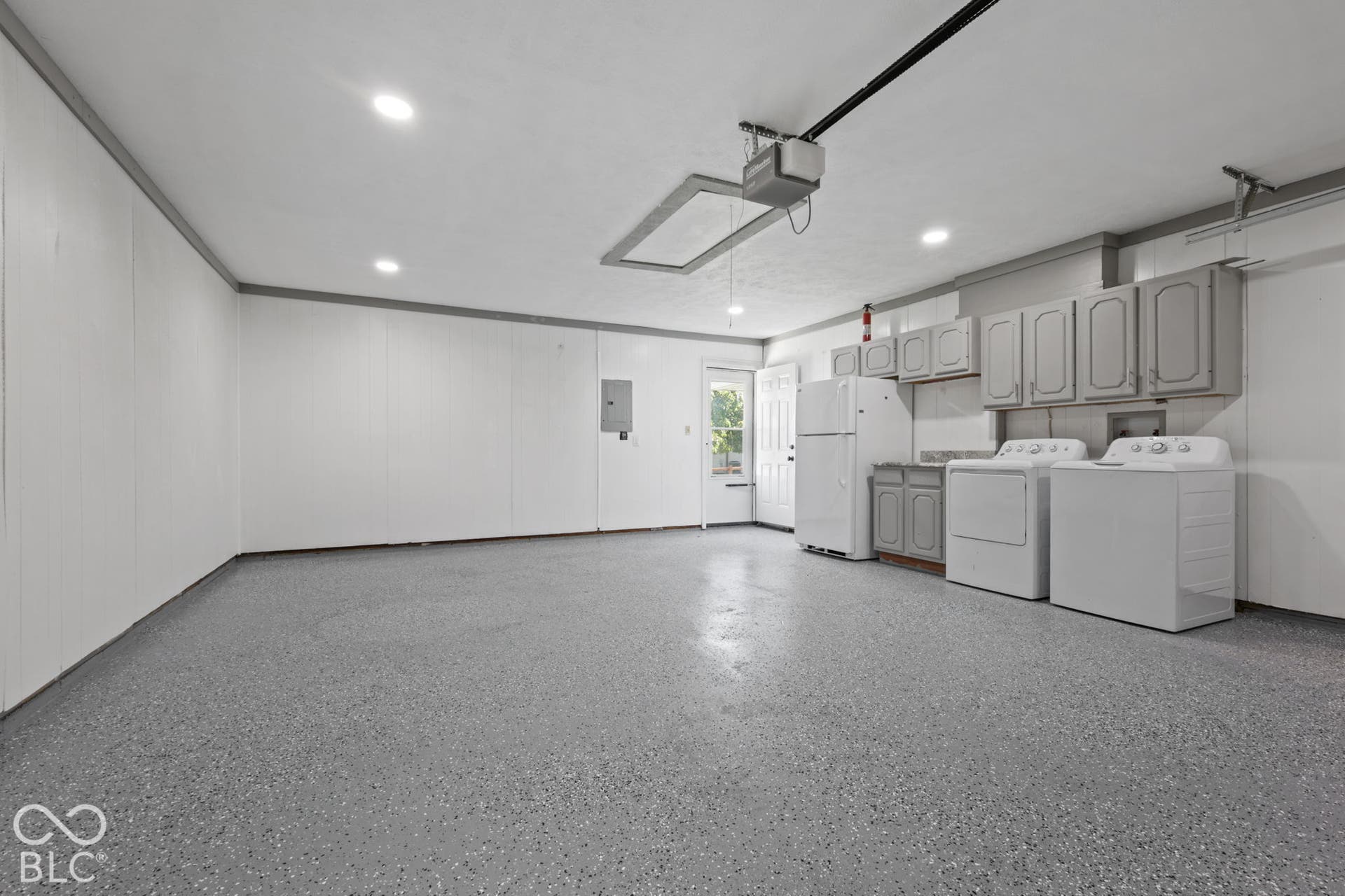 Spacious utility area featuring durable speckled flooring