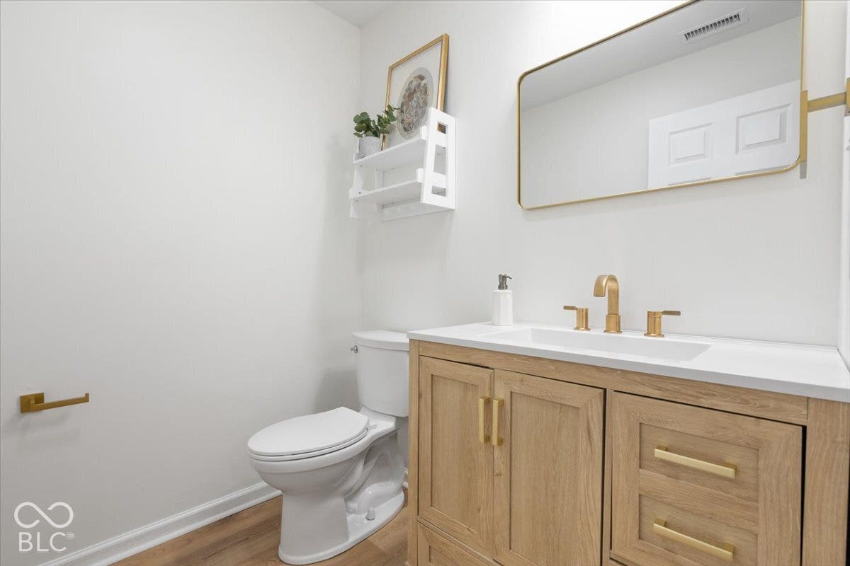 11780 Copper Mines Way, Fishers, IN 46038 Wood-finish vanity with a white countertop and gold-tone fixtures