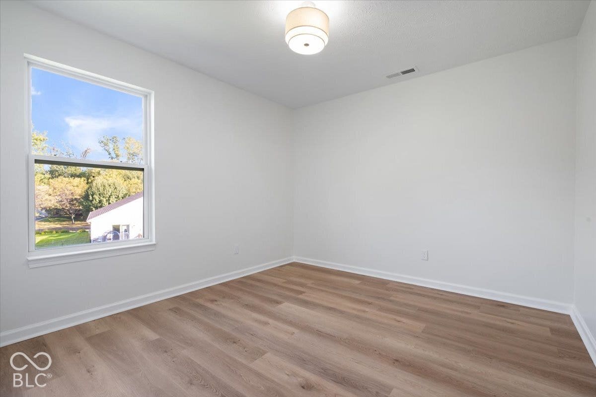 11780 Copper Mines Way, Fishers, IN 46038 Wood-finish flooring with white trim, white walls, and a single window