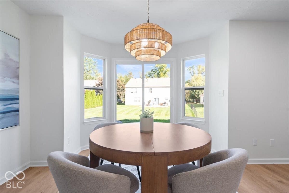 11780 Copper Mines Way, Fishers, IN 46038 Bay window with three pane windows, wood-finish flooring, and a tiered chandelier