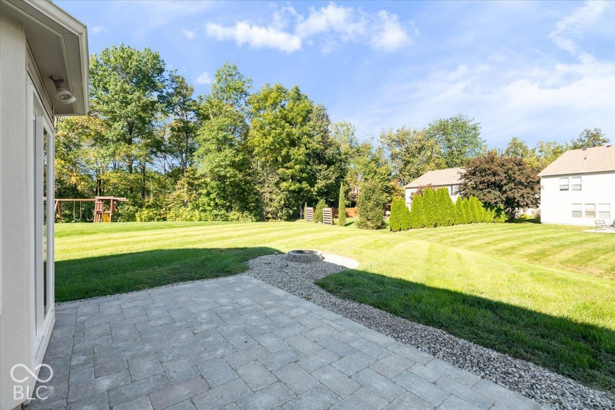 11780 Copper Mines Way, Fishers, IN 46038 Paver patio with a stone fire pit, extensive lawn, and mature trees