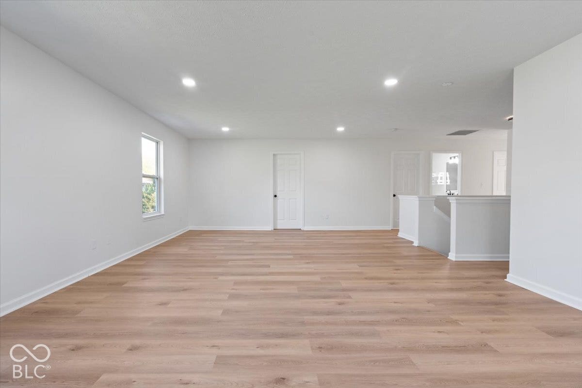11780 Copper Mines Way, Fishers, IN 46038 Recessed lighting illuminates the expansive room featuring wood-finish flooring and white painted walls