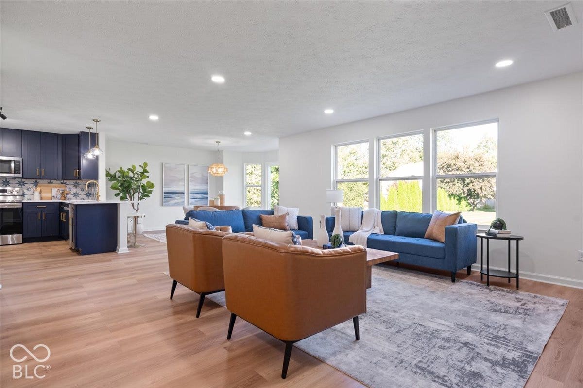 11780 Copper Mines Way, Fishers, IN 46038 Recessed lighting, wood-finish flooring, multiple windows, kitchen with blue cabinetry, and stainless steel appliances