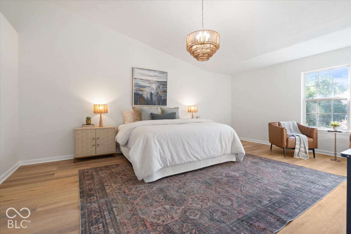 11780 Copper Mines Way, Fishers, IN 46038 Vaulted ceiling with an ornate chandelier, wood-finish flooring, and a large window with natural light