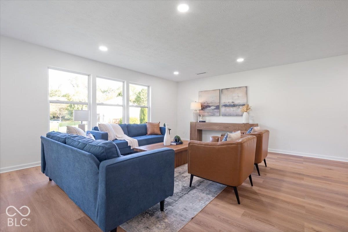 11780 Copper Mines Way, Fishers, IN 46038 Recessed ceiling lighting illuminates a spacious room featuring light wood-finish flooring and multiple windows