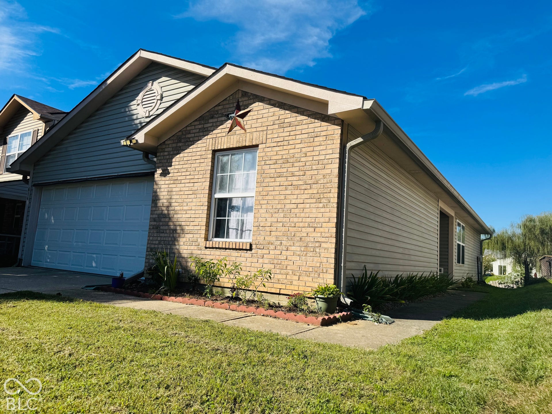 Brick facade and light-toned siding exterior