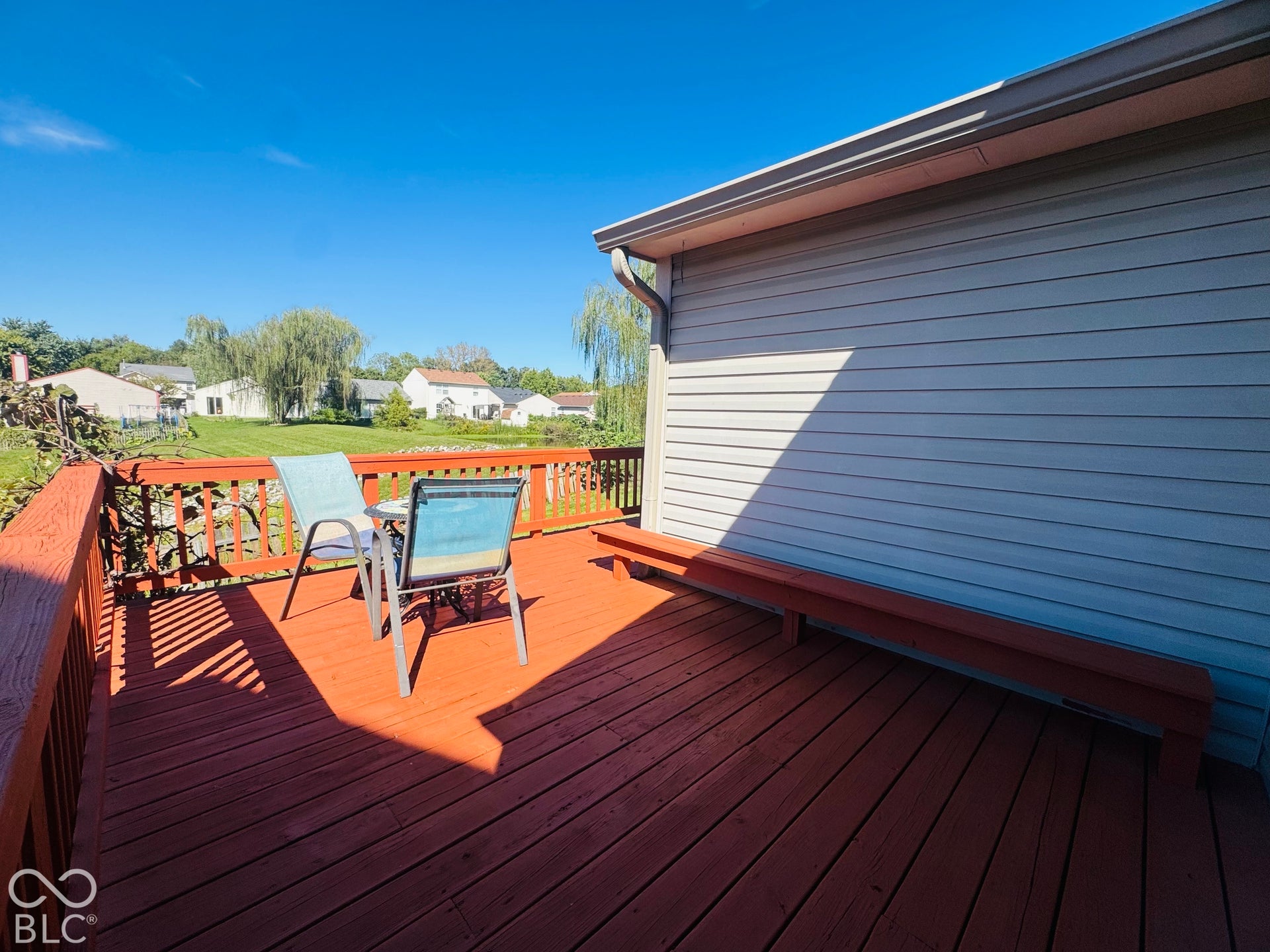 Expansive wood deck with a built-in bench, offering an outdoor living area
