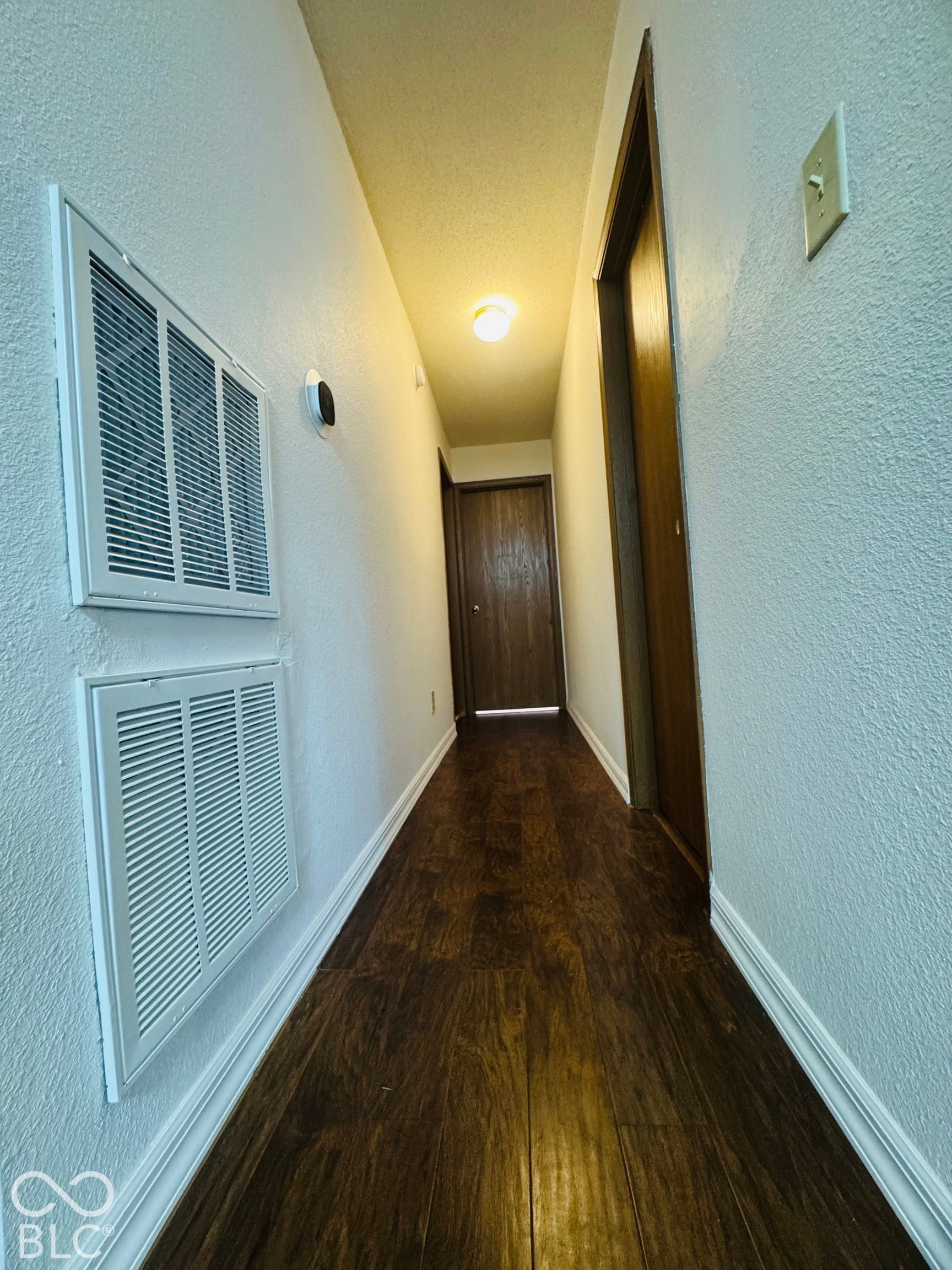Hardwood-finish flooring, white walls, and built-in lighting