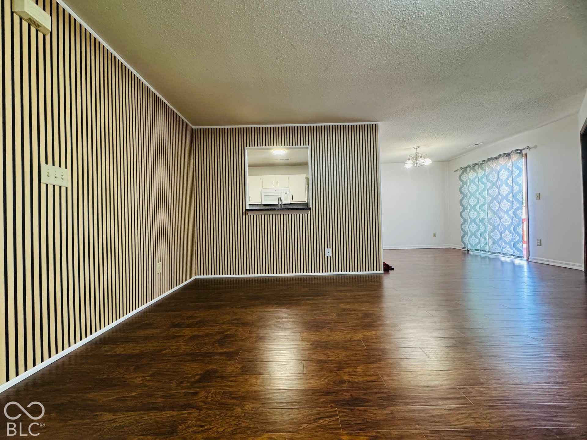 Wood-finish flooring throughout, with a pass-through window to the kitchen