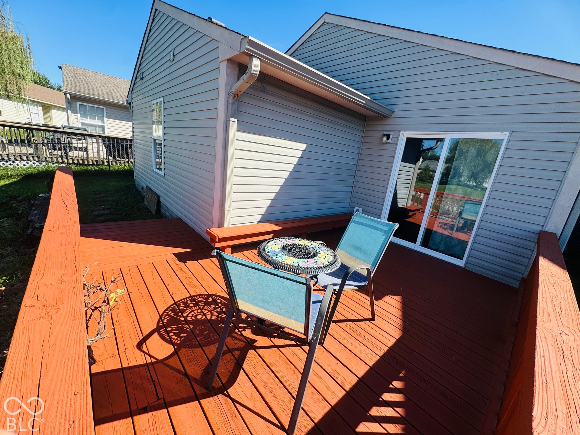 Wood-finish deck with a built-in bench and direct access to the interior via a sliding glass door
